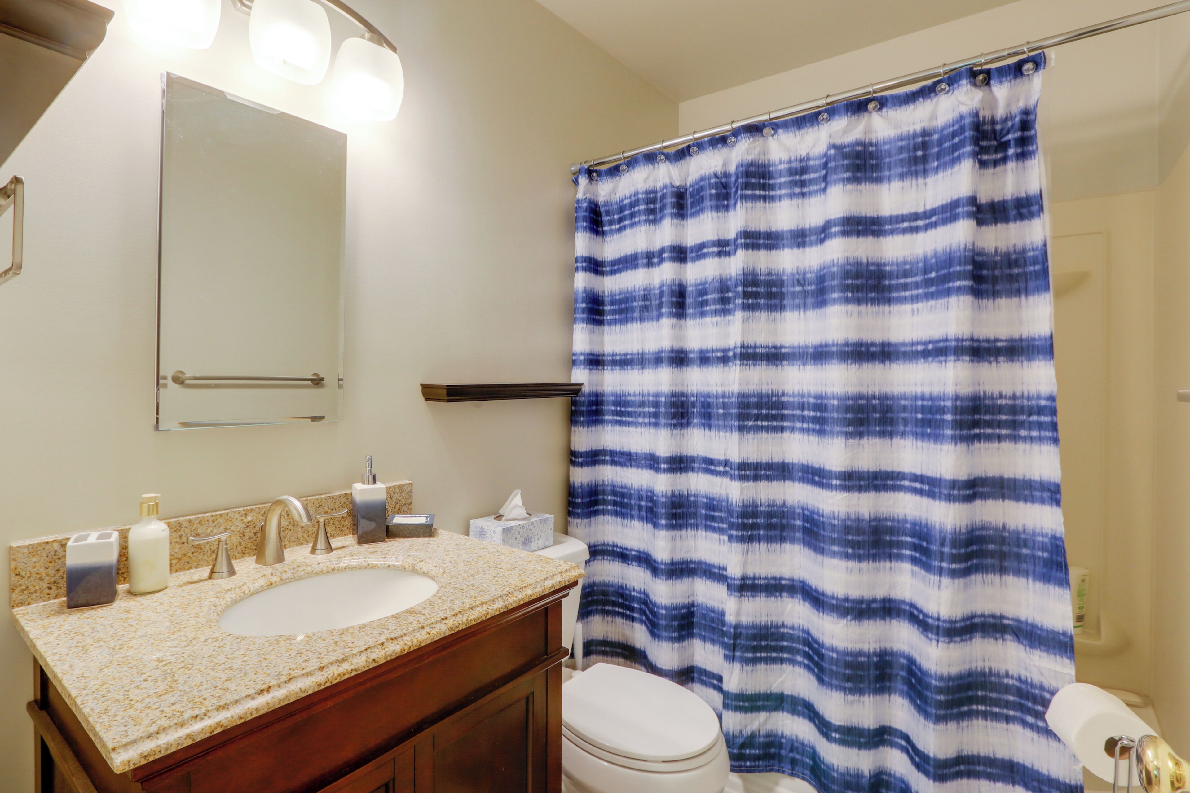 A bathroom with a sink, mirror, and toilet.