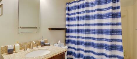 Un baño con lavabo, espejo y retrete.