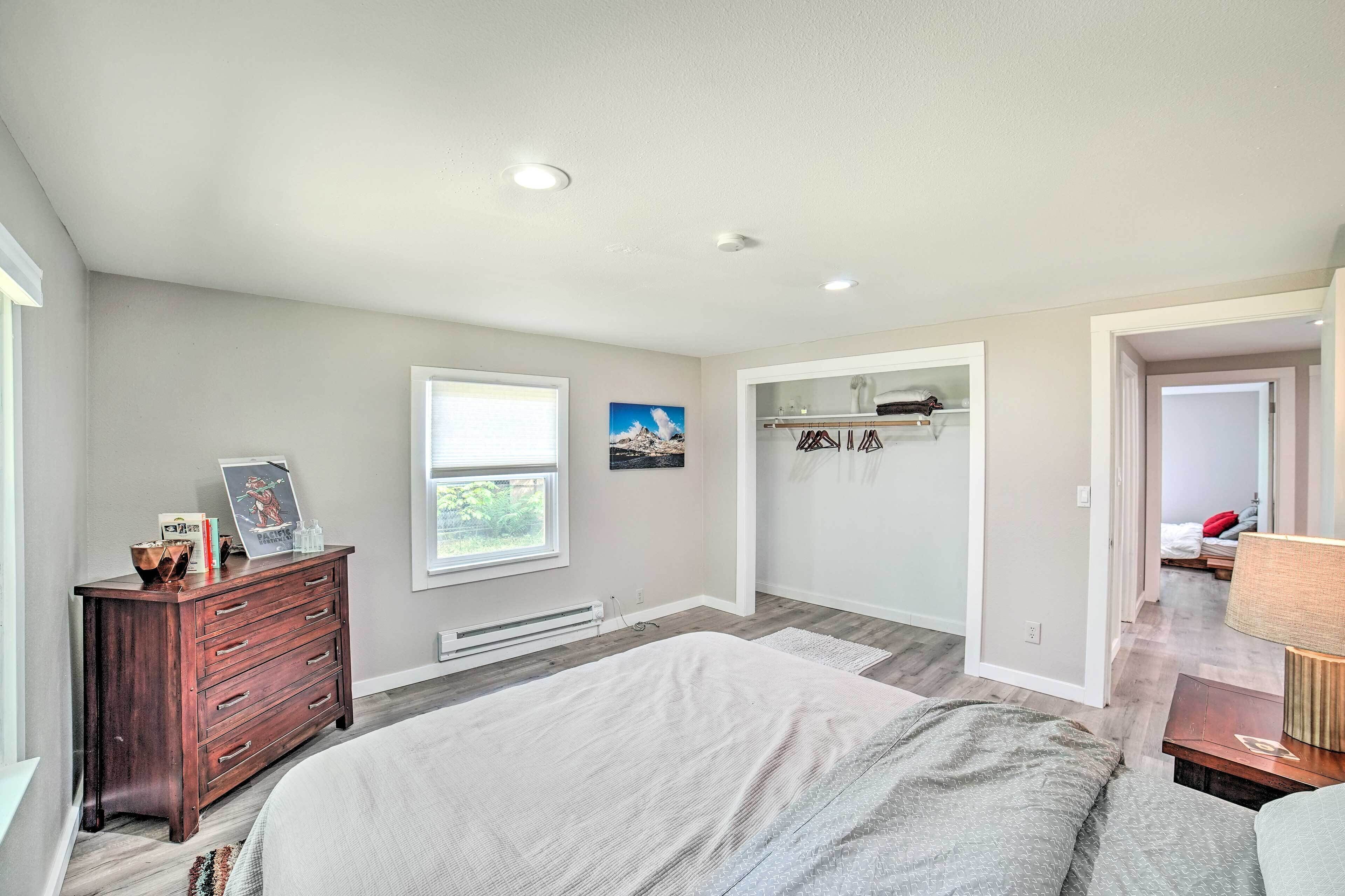 Un dormitorio con cama, cómoda, ventana y estanterías empotradas.
