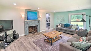 A living room with a fireplace, a television, a sofa, and a coffee table.