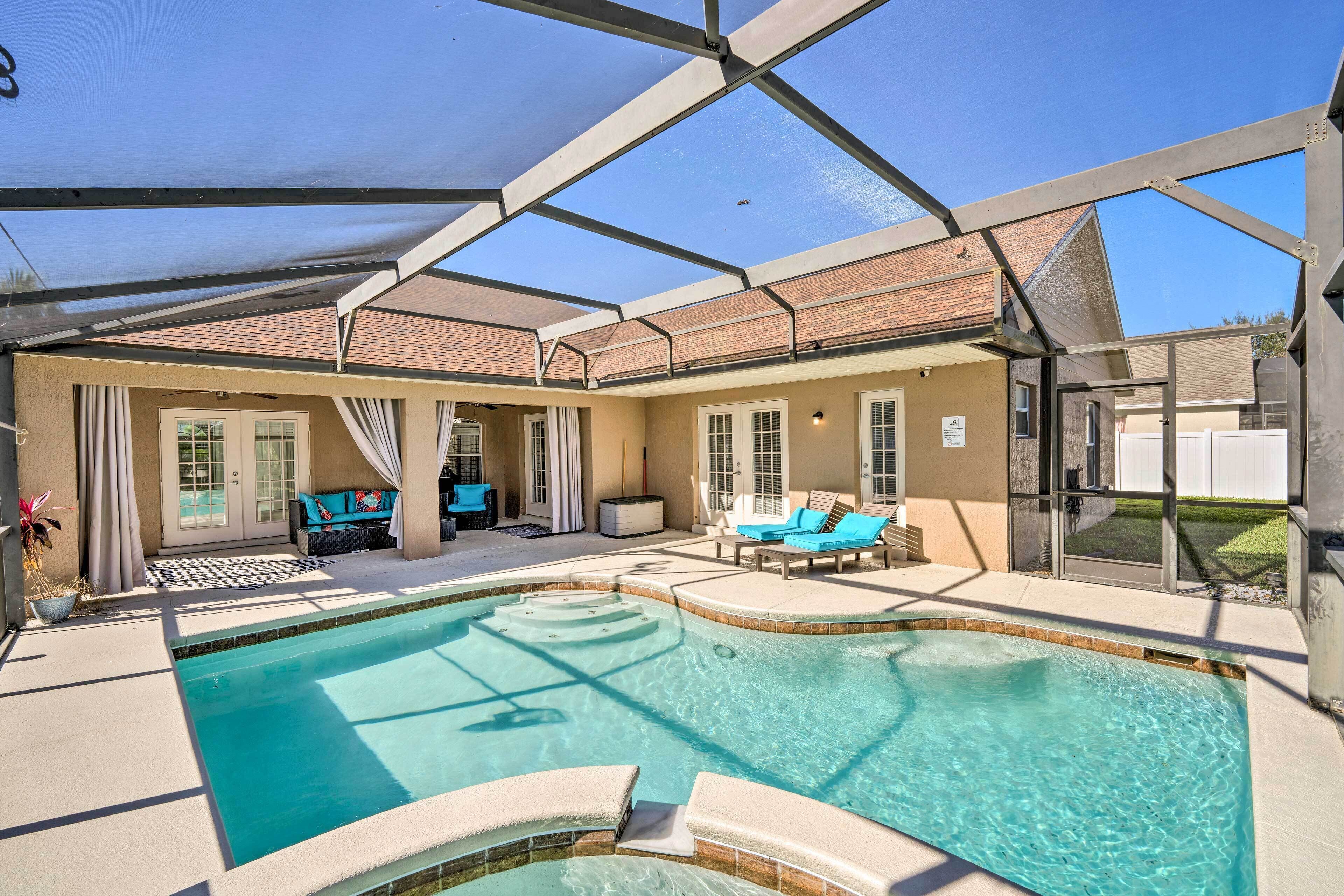 A swimming pool with a covered patio area, including lounge chairs and a seating area.