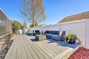 A wooden deck with outdoor furniture and a potted plant.