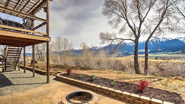 A wooden deck with a fire pit, a covered seating area, and a view of mountains.