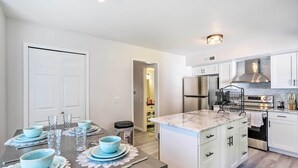A modern kitchen with white cabinets, a stainless steel refrigerator, and a marble countertop. - 5 Mi to UT: Quiet Toledo Duplex Near Parks! (Toledo)