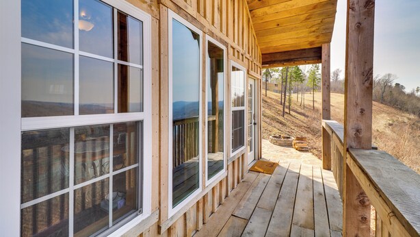 A wooden deck with large windows and a covered porch area. - Peaceful Mountain Air Getaway w/ Fire Pit! (Mountain View)
