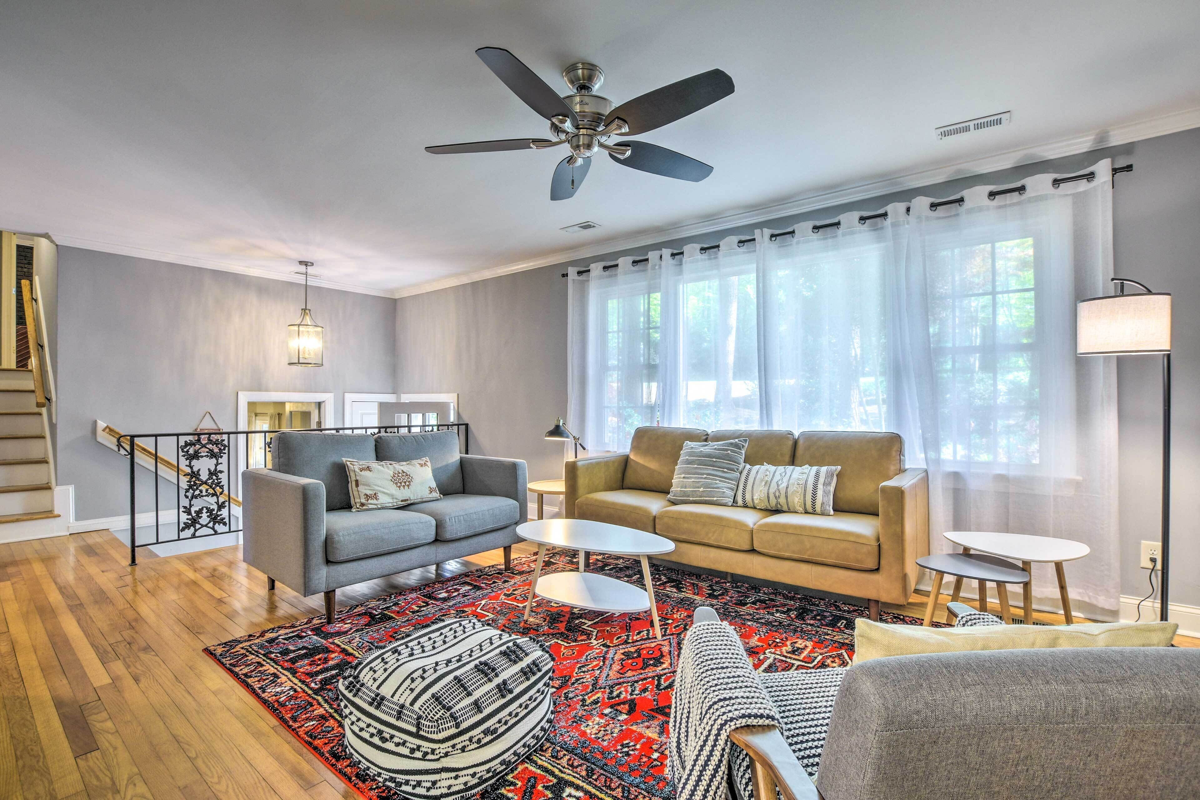 A modern living room with a grey sofa, a beige sofa, a coffee table, and a patterned rug.