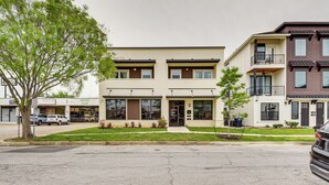 A multi-story building with a flat roof, large windows, and a central entrance.