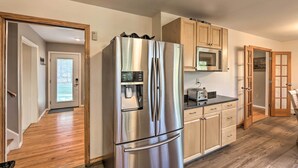 A modern kitchen with a stainless steel refrigerator, wooden cabinets, a microwave, and a toaster. - Family-friendly Woodbury Home With Yard + Deck! (Woodbury)