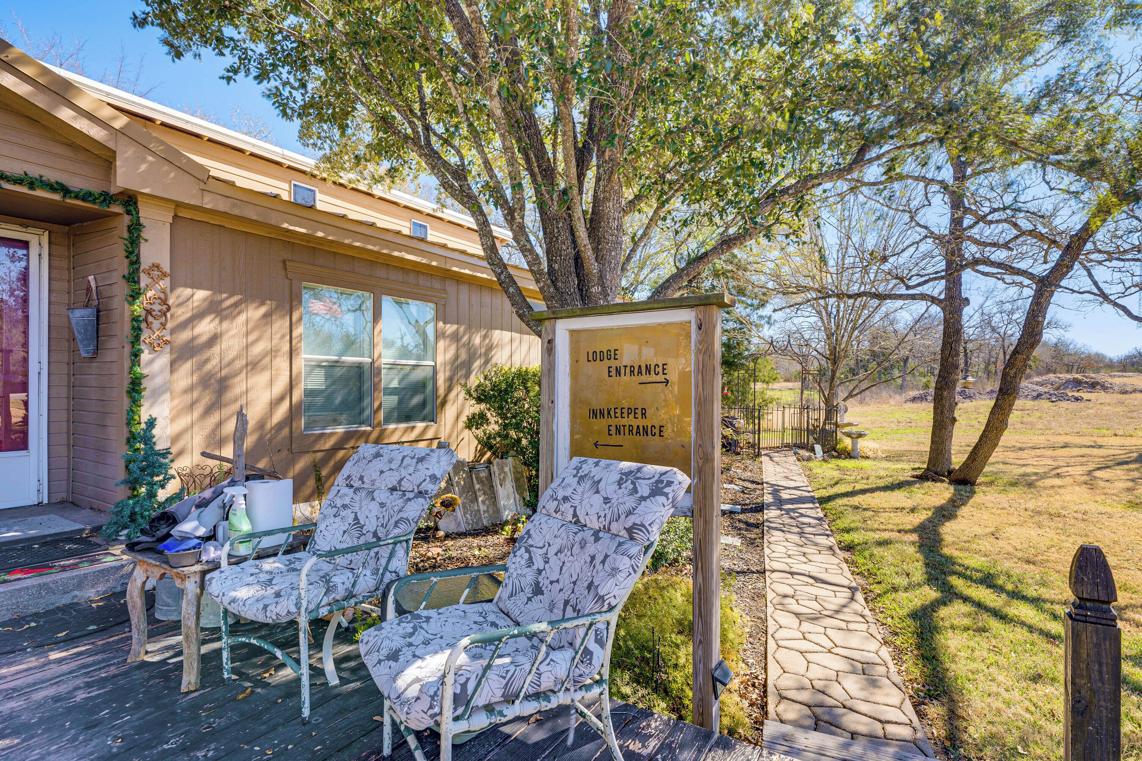 A lodge entrance with a sign indicating the direction to the innkeeper's entrance. There are two chairs outside the lodge.