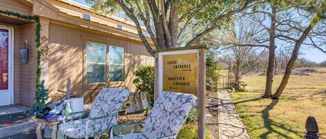 A lodge entrance with a sign indicating the direction to the innkeeper's entrance. There are two chairs outside the lodge.