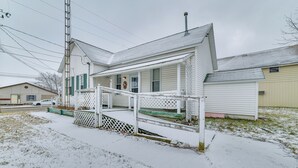 A single-story house with a covered porch and a small front yard. - Historic Houghton Lake Getaway Near Shoreline (Houghton Lake)