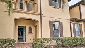 A two-story building with a beige exterior, a balcony with a railing, and a small entrance with a door. - 9 Mi to Disney: Resort Townhome in Davenport! (Davenport)