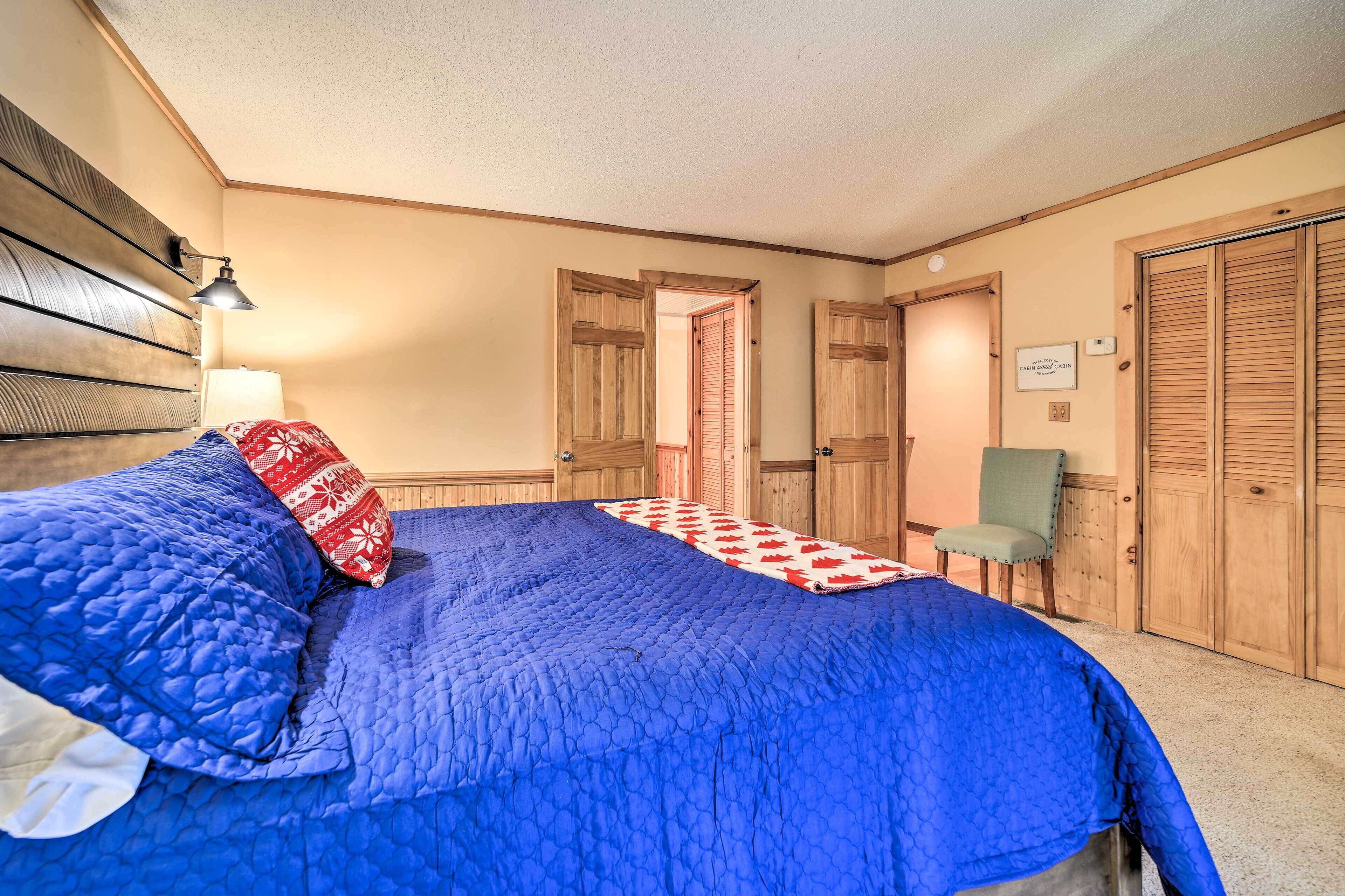 A bedroom with a large bed, a chair, and wooden doors.