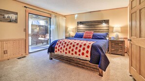 A bedroom with a large bed, two bedside tables, a wooden headboard, and a sliding glass door leading to a balcony. - Sunny Sapphire Townhome w/ Resort Amenities! (Sapphire)