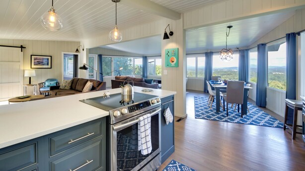 A modern kitchen with a central island, built-in oven, and pendant lighting.