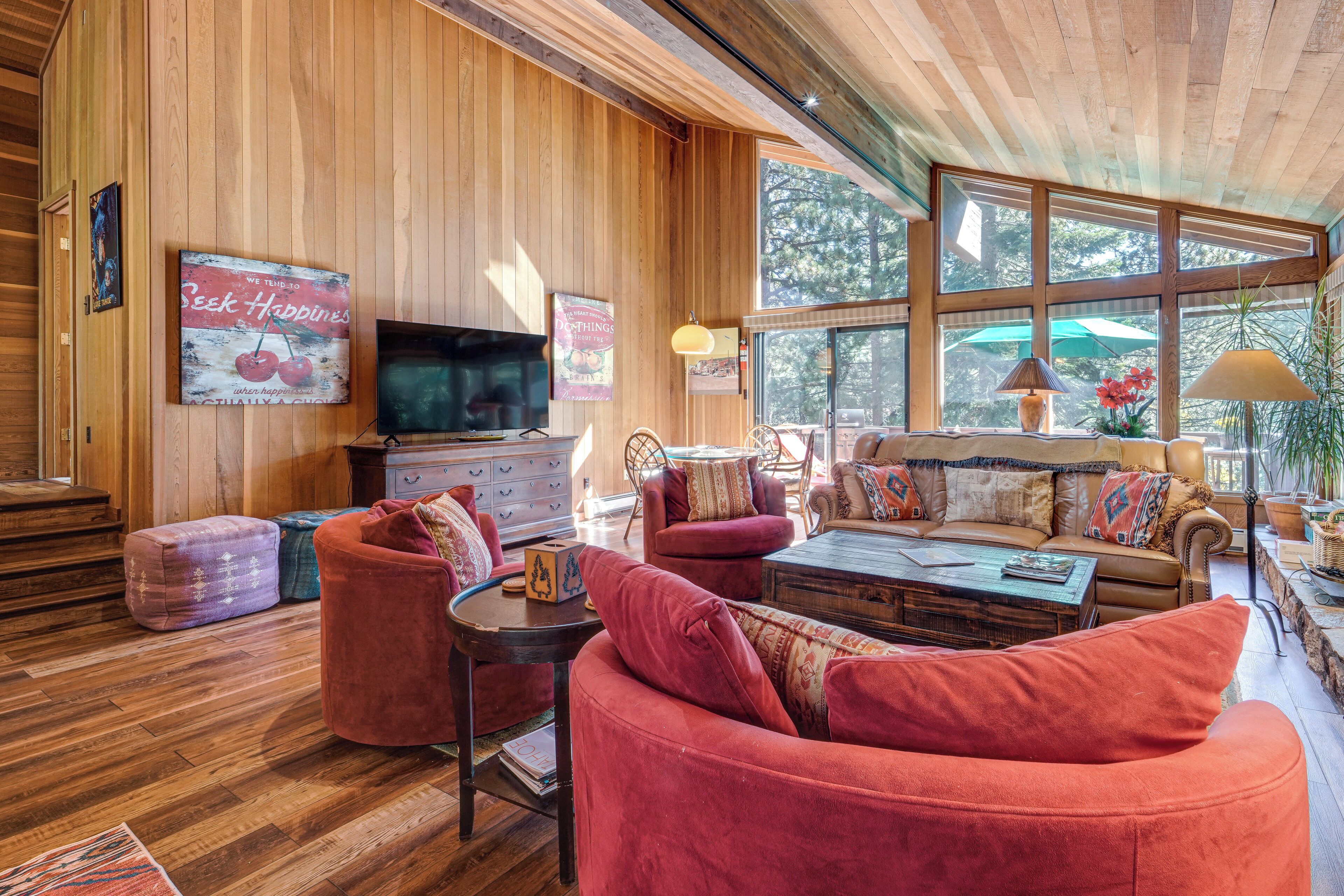 A cozy living room with a wooden interior, a television, and comfortable seating.