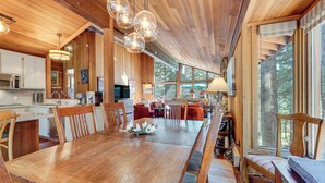 A spacious wooden interior with a large dining table, wooden chairs, and a cozy seating area with a sofa and armchairs. - Family-friendly Truckee Cabin Near Ski Shuttle! (Truckee)