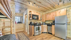 Une cuisine de taille réduite, dotée de meubles en bois, d’un four à micro-ondes, d’une cuisinière et d’un réfrigérateur.