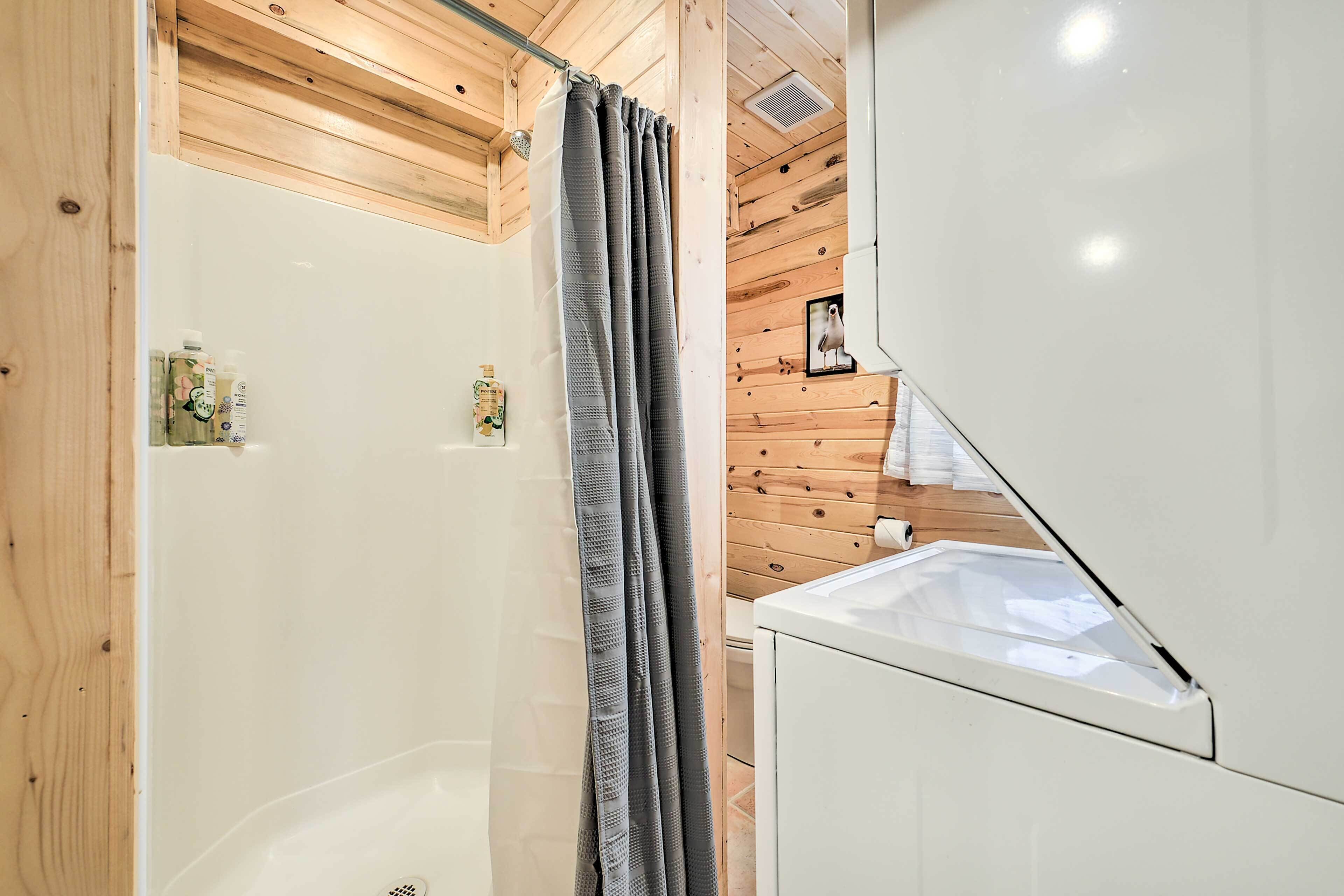 A bathroom with a shower, a toilet, and a sink.