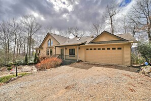 A single-story house with a garage, a front porch, and a gravel driveway. - Sapphire 5BR Luxe: 5 Private Baths, Mtn Views (Sapphire)