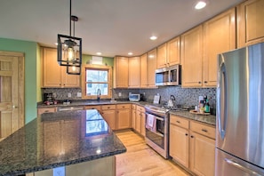 A modern kitchen with granite countertops, stainless steel appliances, and wooden cabinets. - Wintergreen Resort Cabin: Near the Slopes! (Roseland)