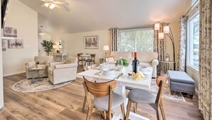 A spacious living room with a dining area, wooden flooring, and a ceiling fan. - Waterfront Cottage w/ Private Beach + Deck! (Colonial Beach)