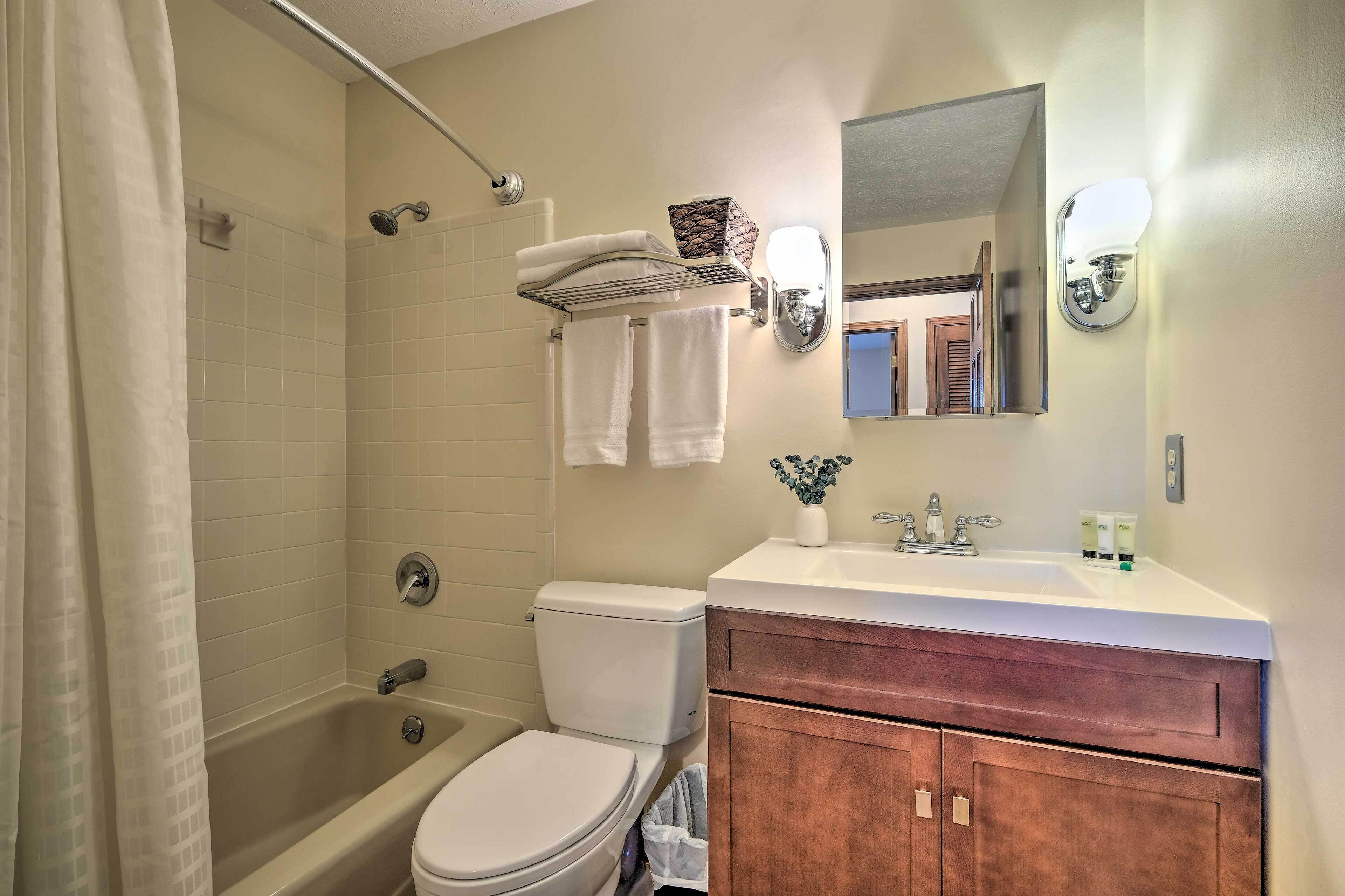 A bathroom with a bathtub, toilet, sink, and vanity.