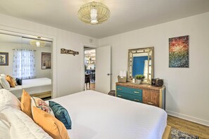 Un dormitorio con una cama grande, un aparador, un espejo y una lámpara en el techo.