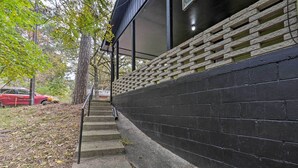 A staircase leading up to a building with a black exterior and a brick retaining wall. - Renovated Eureka Springs Home - 1 Mi to Downtown! (Eureka Springs)