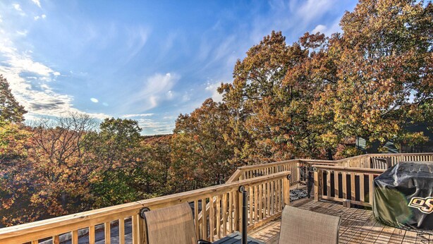 A wooden deck with outdoor seating and a grill.