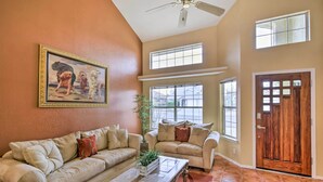 A spacious living room with two sofas, a coffee table, and a painting on the wall.