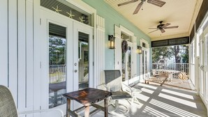 A covered porch with white shutters, a ceiling fan, and outdoor seating. - Santa Rosa Beach Home w/ Pool, Hot Tub & Deck! (Santa Rosa Beach)