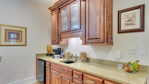 A kitchen with wooden cabinets, a granite countertop, a dishwasher, and a decorative bird figurine. - Santa Rosa Beach Home w/ Pool, Hot Tub & Deck! (Santa Rosa Beach)