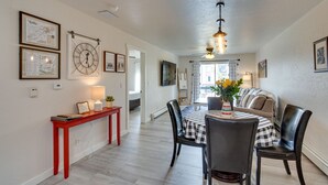 A dining area with a checkered tablecloth, black chairs, and a red console table with a lamp. - Grand Junction Vacation Rental: Indoor Pool Access (Grand Junction)