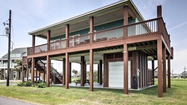 Un bâtiment à deux étages doté d’un balcon, d’une terrasse couverte et d’un garage.
