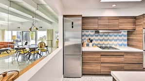A modern kitchen with wooden cabinets, a stainless steel refrigerator, and a tiled backsplash. - Furnished Patio + Pool Access: Palm Springs Condo (Palm Springs)