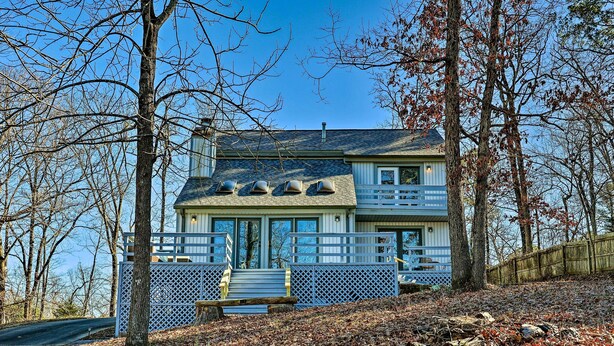 A two-story house with a blue exterior, a front porch, and a wooden fence. - Near Ouachita River: Home w/ Deck in Hot Springs (Hot Springs)