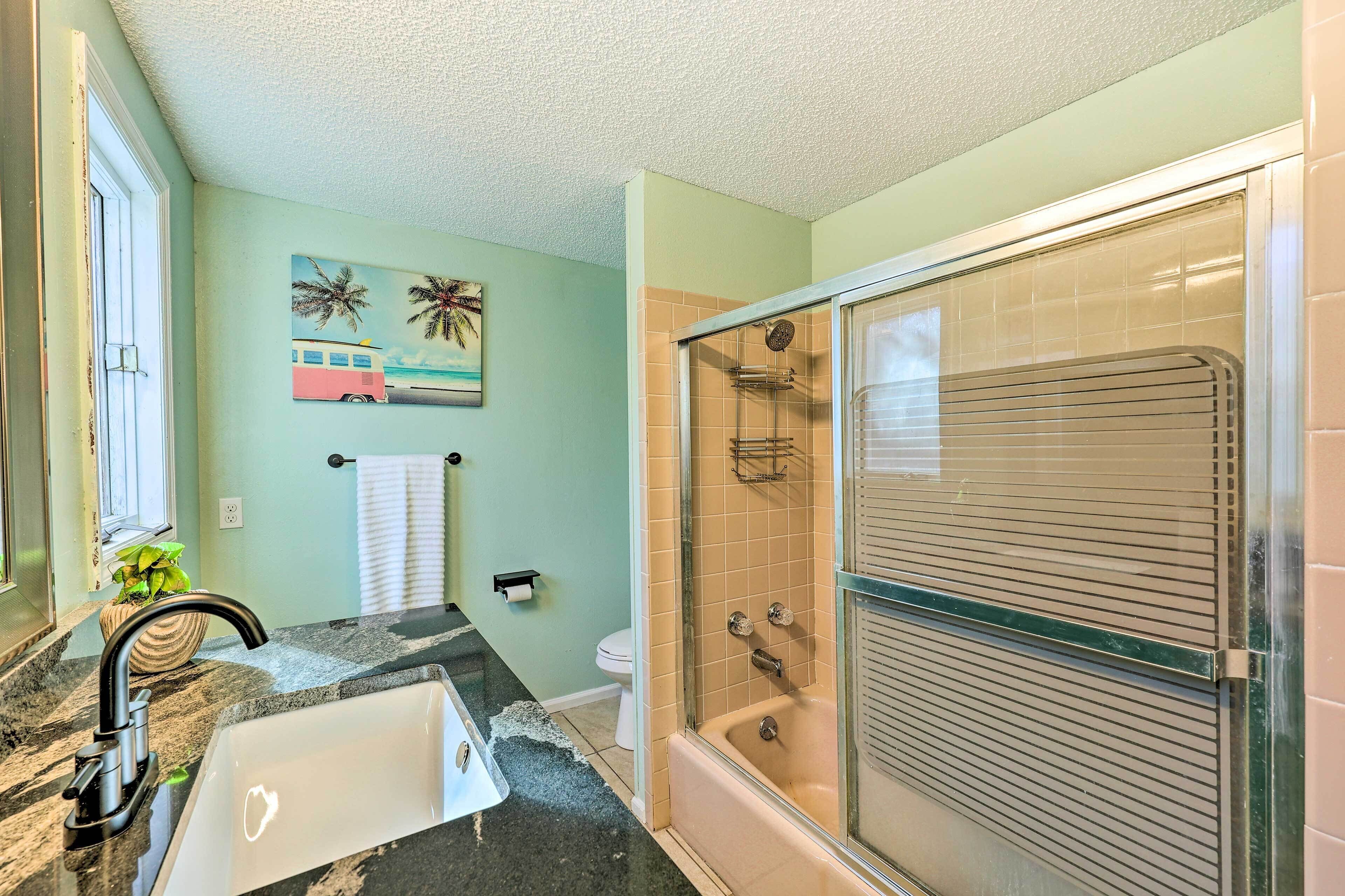 A bathroom with a bathtub, a shower, a sink, and a toilet.