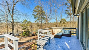 A wooden deck with outdoor seating and a view of the surrounding forest. - Near Ouachita River: Home w/ Deck in Hot Springs (Hot Springs)