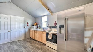 A kitchen with a stainless steel refrigerator, wooden cabinets, a stove, and a window. - Dog-friendly Huntsville Home, ATV Authorized Route (Huntsville)