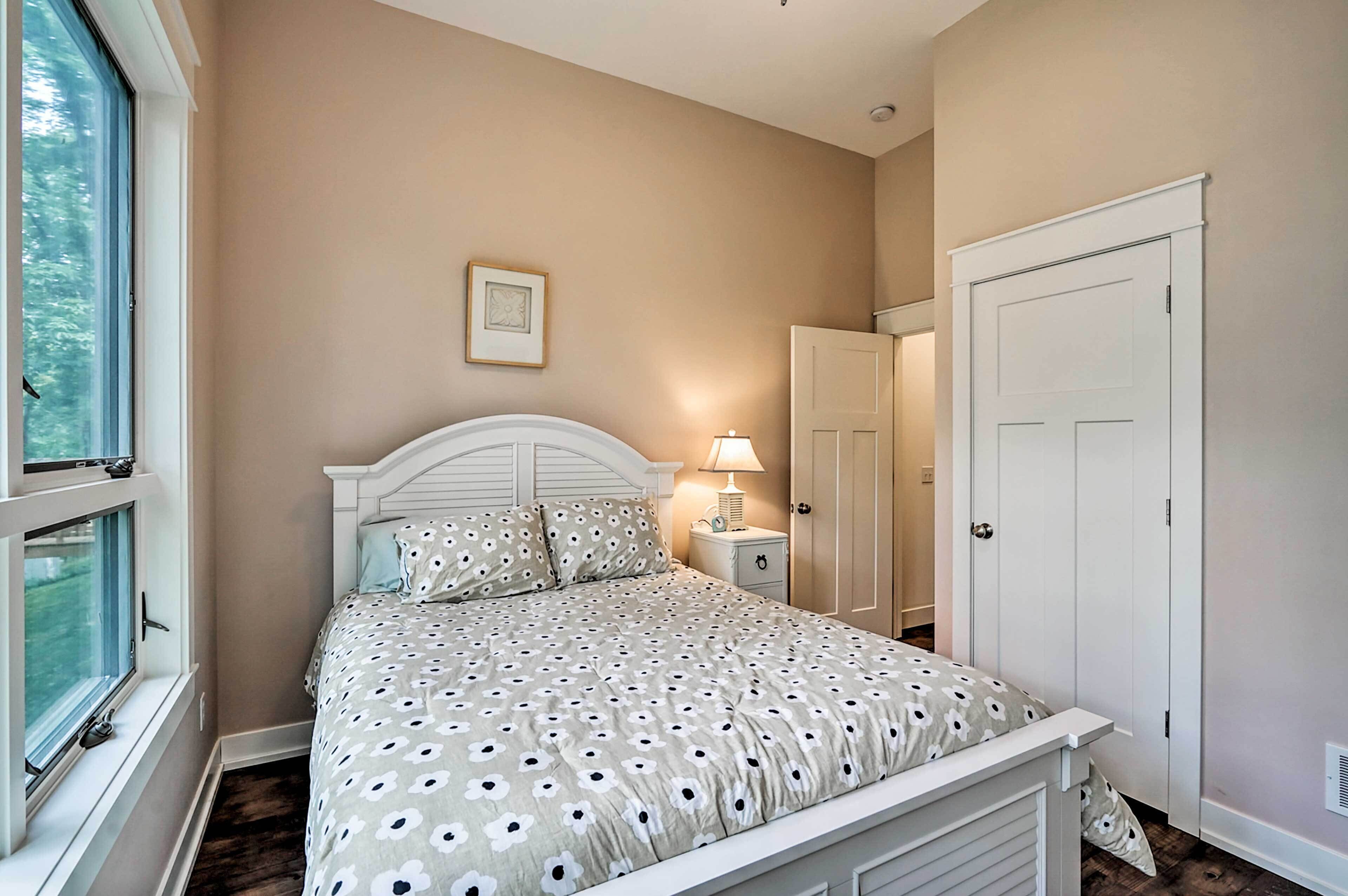 Une chambre à coucher avec un lit, une table de chevet et une fenêtre.