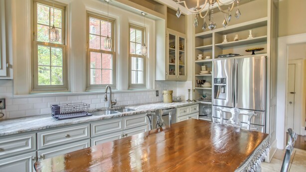 A kitchen with a wooden island, white cabinetry, and a stainless steel refrigerator. - Family Laurinburg Home w/ Private Yard & BBQ (Laurinburg)