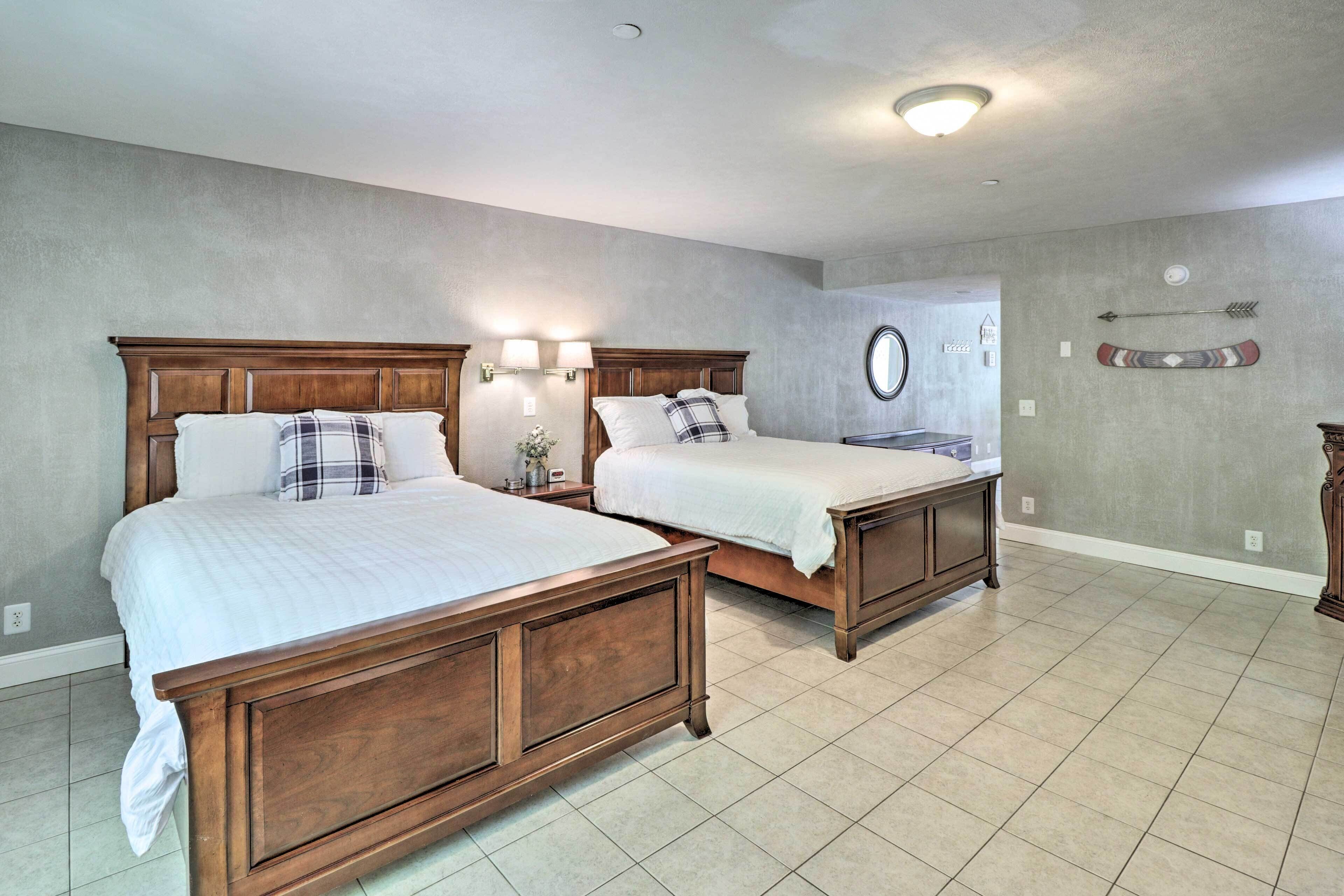 A bedroom with two wooden beds, a round mirror, and a wall-mounted arrow decoration.