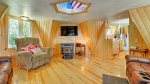 A cozy cabin interior with a wooden interior, a fireplace, and a television mounted on the wall. - 'snowflake Cabin' - Mins to Cody & Red Lodge! (Powell)