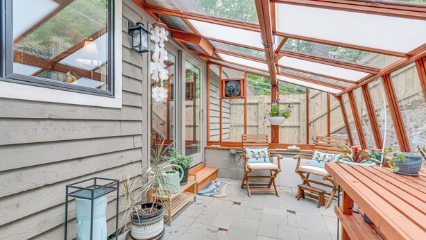 A sunroom with a wooden bench, chairs, and potted plants. - Cozy Hideaway w/ Grill, 17 Mi to Asheville (Black Mountain)