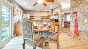 A spacious kitchen with a dining area, stone wall, and a ceiling fan. - Cozy Hideaway w/ Grill, 17 Mi to Asheville (Black Mountain)