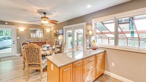 A spacious kitchen with a large island, wooden cabinets, and a ceiling fan. - Cozy Hideaway w/ Grill, 17 Mi to Asheville (Black Mountain)