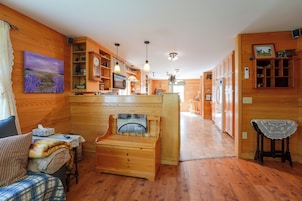 Un interior acogedor con paredes de madera, chimenea, comedor y cocina.