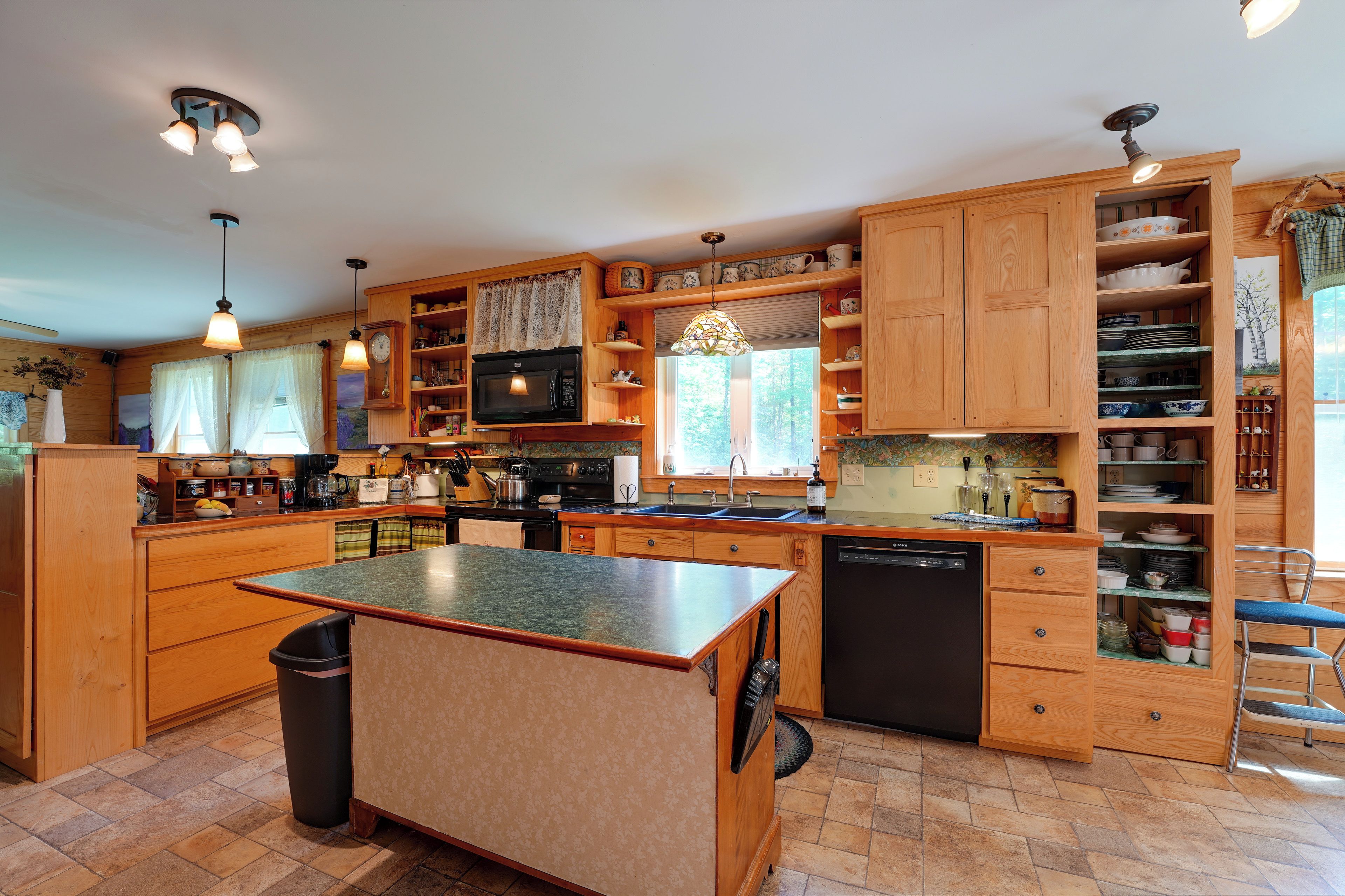 Una cocina amplia con armarios de madera, una isla central y lavavajillas.