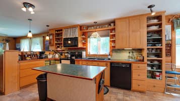 A spacious kitchen with wooden cabinets, a central island, and a dishwasher.